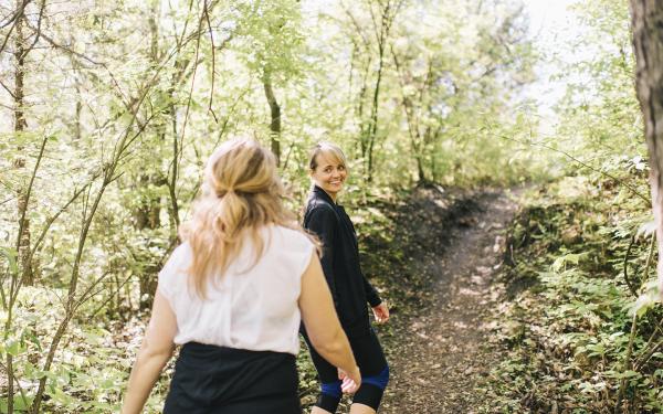 Two women walking through the forest together